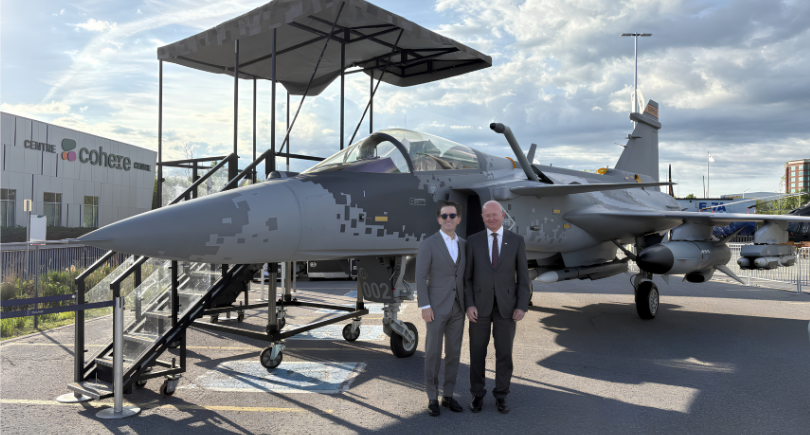 Representatives from CAE and Saab exchange documents after signing a memorandum of understanding to collaborate on Gripen training, simulation and mission support for Canada.