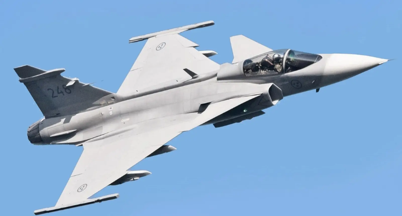 Gripen fighter jet flying against a clear blue sky