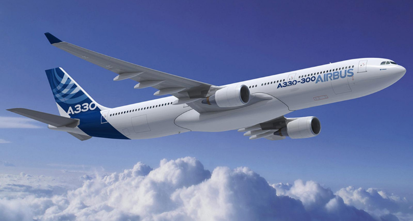 Airbus A330-300 aircraft in flight above clouds