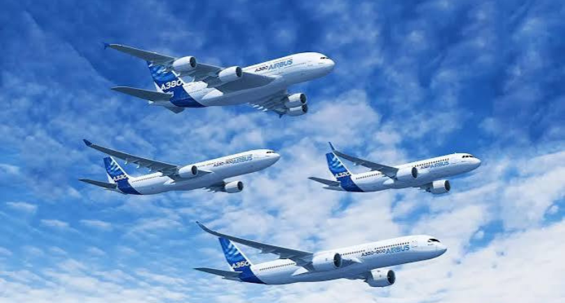Four Airbus A330 aircraft flying against a blue sky.