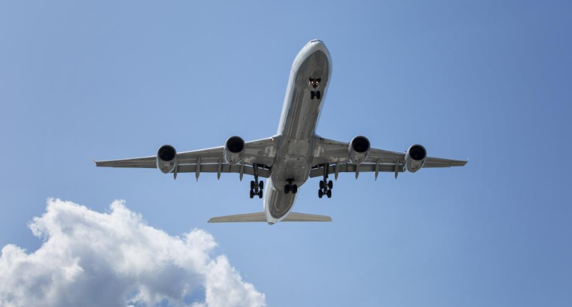Commercial aircraft flying under a clear sky