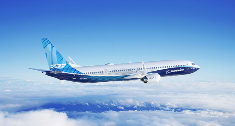 Boeing 737 MAX aircraft flying above clouds