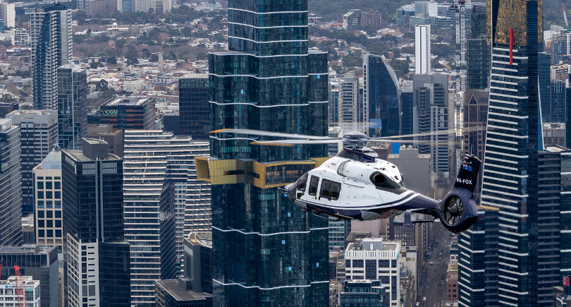 Linfox Airbus H160 helicopter flying over Melbourne city