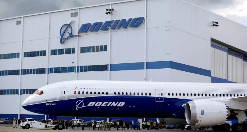 Boeing 787-10 parked outside a Boeing facility under a cloudy sky.