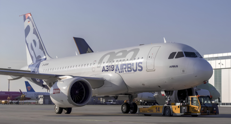 Airbus A319 aircraft displayed on the apron outside an aircraft assembly facility.