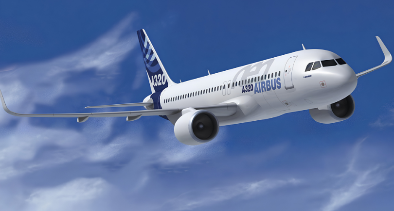 Airbus A320 aircraft flying against a blue sky with clouds.