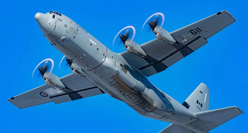 Royal Canadian Air Force CC-130J Hercules aircraft flying against a blue sky.